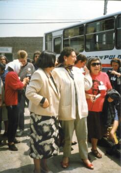 Grupo de mujeres al costado de un bus